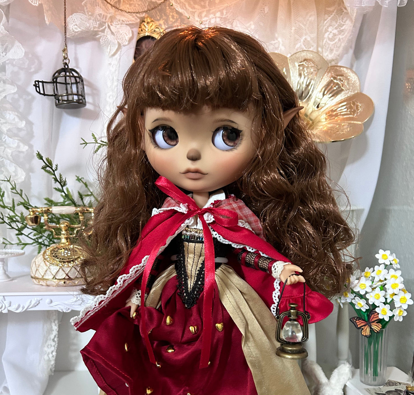 Detailed doll with brown hair and a red outfit in a decorative setting